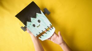 This project will turn an ordinary paper plate into a confronting Frankenstein face, complete with a stitched up jaw and neck bolts.  There is a lot of coloring in with this Halloween craft idea, which you can substitute for painting if you want a different kind of activity. There is also some threading of yarn that will be a bit more challenging for a younger toddler, but will help develop those motor skills if given some time.  Full written instructions are included in this post, along with pictures for each step and a video demonstration.  [toc] Prepare Your Paper Plate Craft Materials If you want to stick with coloring in rather than painting then your craft materials will be very simple, and mostly mess free.  Again, feel free to interchange your crayons for paint. This will require a bit more time when you factor in time to dry and cleaning up the paint brushes and table covering.  Paper Plate Frankenstein Video Demonstration Check out the time-lapse video below of the project being completed from start to finish.  After you see how the project comes together it will be much easier to do with your kids as you work through the written instructions. [mv_create key="18" type="diy" title="How to Make a Frankenstein Paper Plate Craft" thumbnail="https://katherinerosman.com/wp-content/uploads/How-to-Make-a-Frankenstein-from-a-Paper-Plate.jpg"] Why Make a Frankenstein Face Craft While there is not a lot of educational benefit in Frankenstein's monster, it will certainly get them into the Halloween spirit.  This legendary character is more than 200 years old and is a permanent fixture when Halloween decorations go up, and trick or treat costumes are decided.  It is easy to create this project and while he has some scary features it is a fun decoration to place around the house. Plus there is always a benefit to creating something from ordinary items like a paper plate.  For More Halloween Craft Ideas Check out all of our Halloween craft projects suitable for toddlers here.  Each activity comes complete with written instructions, pictures, and videos of the project being completed.  Projects include: Lollipop Ghost Craft Final Word Halloween is the perfect time to explore some unusual craft ideas and create some characters that you wouldn't normally do with kids.  This Frankenstein craft idea has just the right mix of weird, without being too scary for your children, and is a great addition to your Halloween decorations this year. 